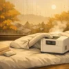 alt="秋の朝、結露した窓のそばで布団乾燥機が温風を送っている様子。落ち着いた寝室の雰囲気を描いたミニマルアニメ風イラスト。"